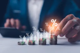 Dividend and interest rates with symbols and arrows up on stacks of coins