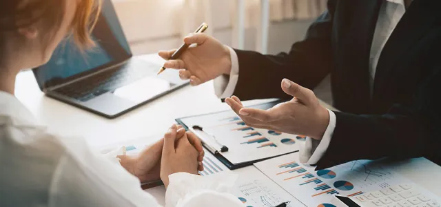Advisor discussing plan of investment of financial report to clients